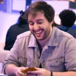 André 'Cast' Bruni segurando cartas Pokémon numa mesa de jogo